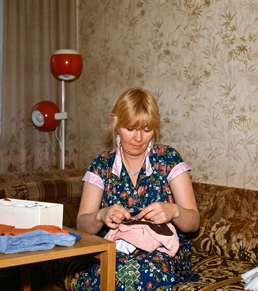 Taastatud värvidega foto naisest laua taga käsitööd tegemas.