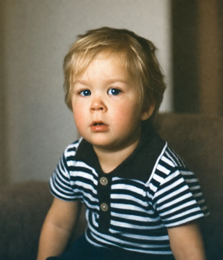 Taastatud portreefoto triibulise särgiga blondist väikelapsest.